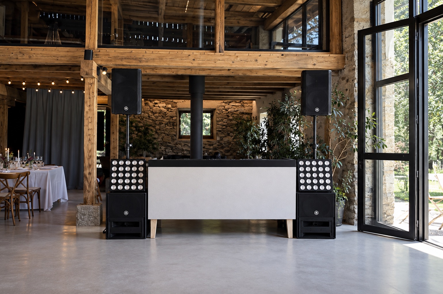 DJ-Pult mit Yamaha-Tonanlage und Lichtpaneelen in einer Hochzeitslocation mit Holzbalken und Steinwand