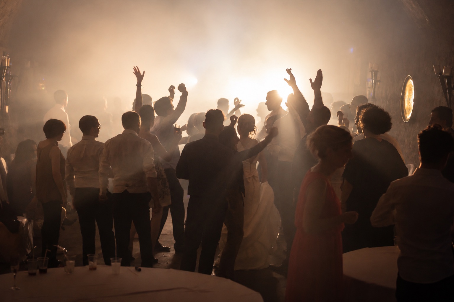 Volle Tanzfläche bei einer Hochzeit im Gegenlicht, Gäste mit erhobenen Armen